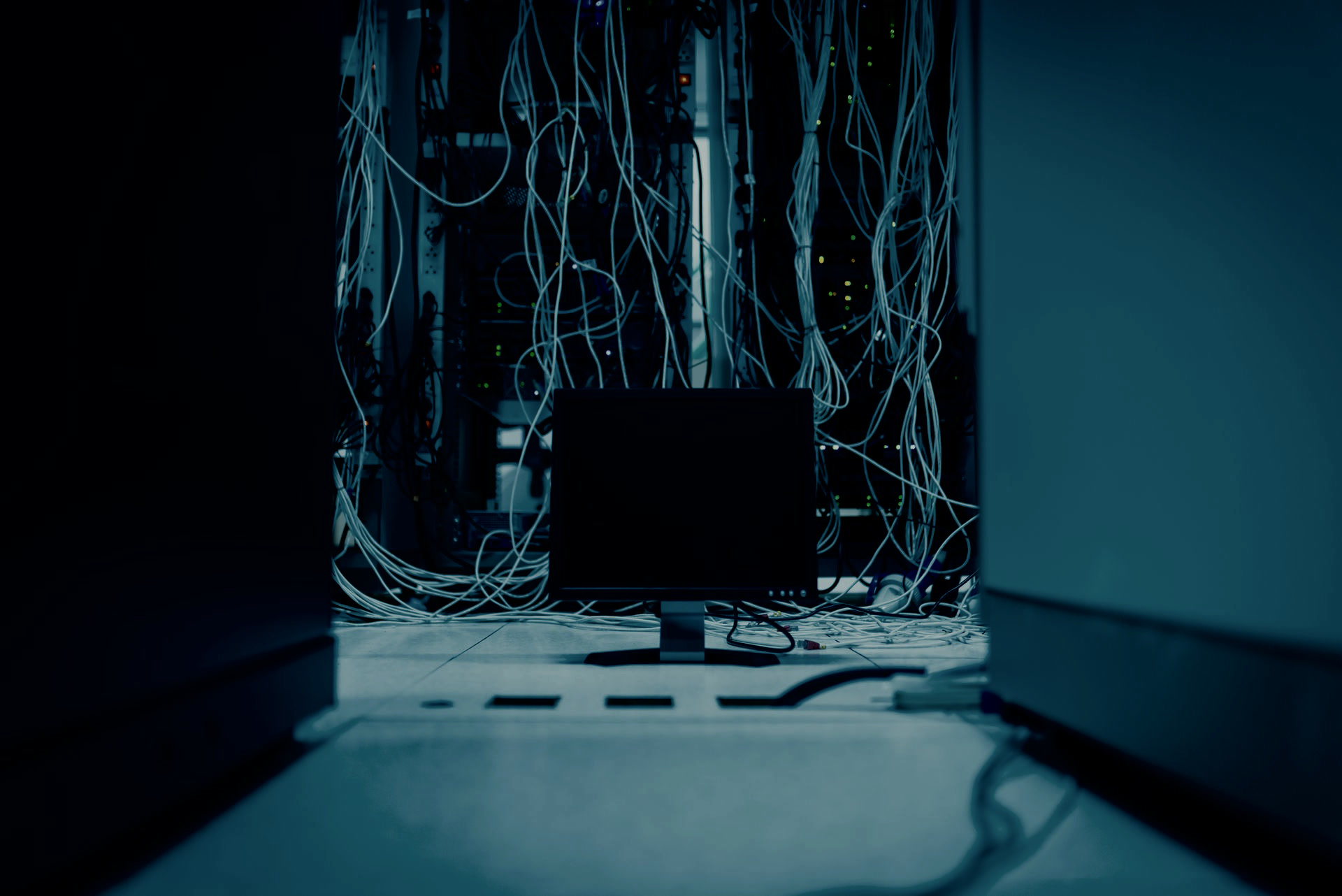 Dark server aisle with hanging cables — technical setup, not a portrait